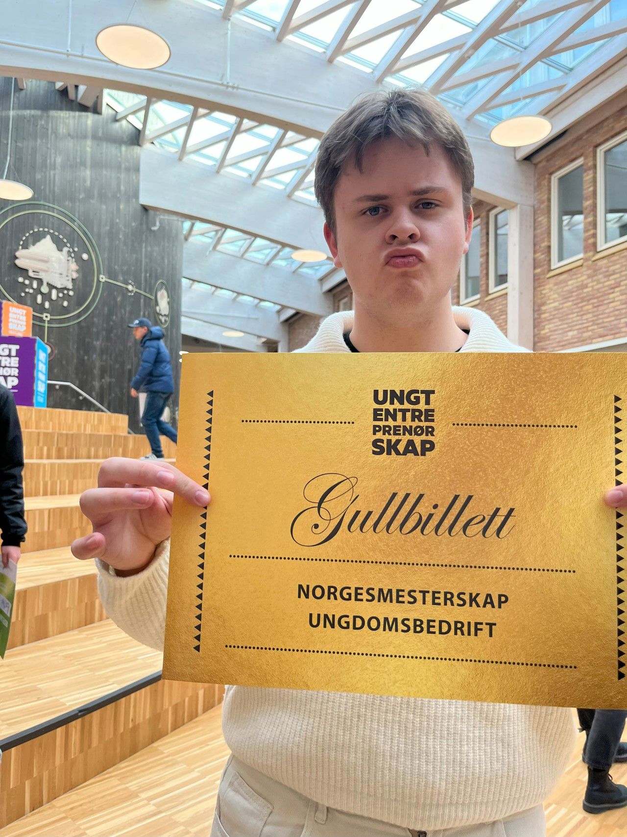 Leo Moen Elgsaas poserer stolt med gullbilletten til Norgesmeisterskapet for ungdomsbedrifter i handa.
