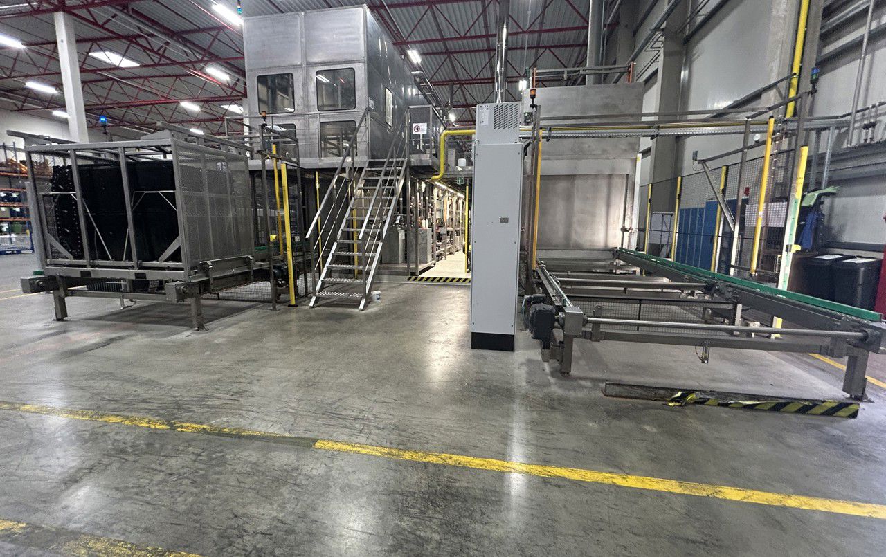 Renseanlegg for produksjon – deksel blir vaska og sendt vidare til høgre for avlasting med gaffeltruck