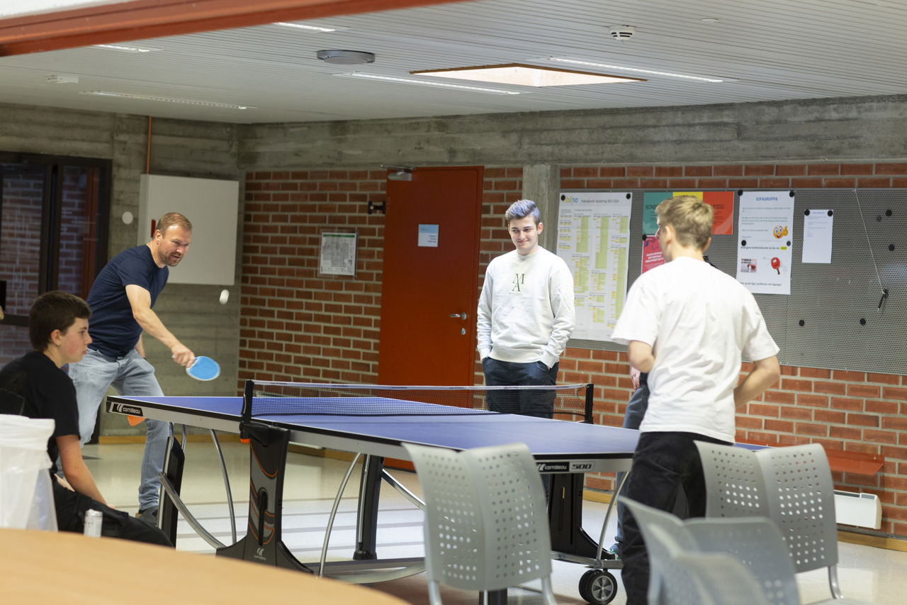 Lærar og elevar som spelar bordtennis på skulen.